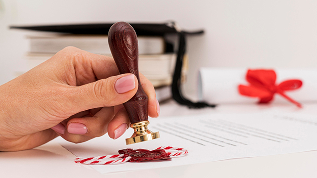 Person using a wax seal for graduation diploma certificate