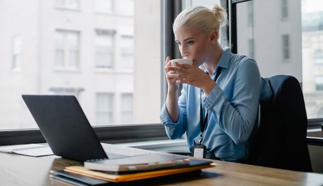 Managerin trinkt Kaffee bei der Arbeit