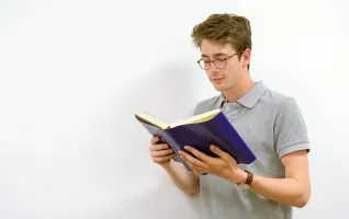 Student reading a book about sales psychology