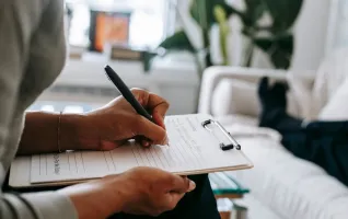 woman writing on a clipboard during therapy session