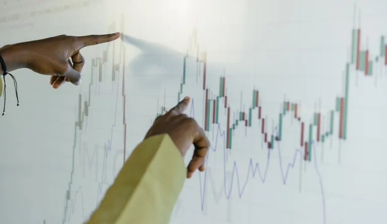 Fingers pointing at business informatics graph on screen