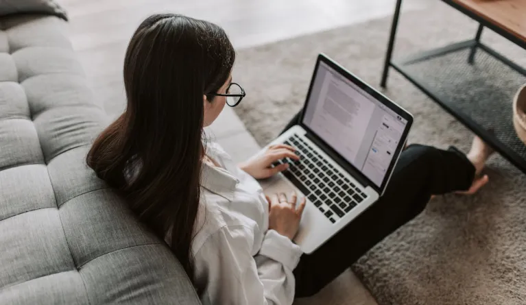 Woman pursuing MBA writing on her laptop