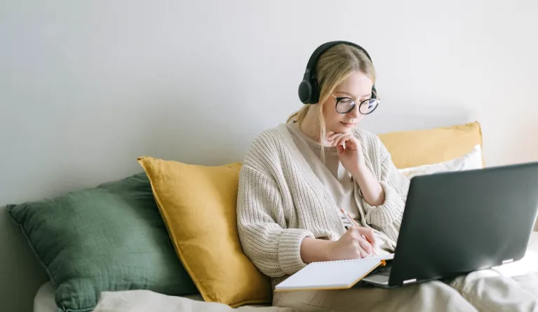 Woman taking notes during a distance learning class