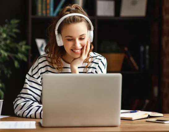 Junge Studentin sitzt am Laptop und studiert Wirtschaftsinformatik berufsbegleitend