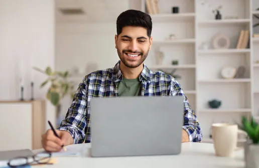 Student sieht sich am Laptop Inhalte des Masterstudiums der Angewandten Psychologie für die Wirtschaft im Fernstudiums an 