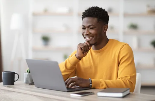 Student sieht sich am Laptop Inhalte des Master Vertriebspsychologie Fernstudiums an 