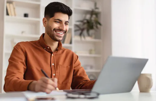 Student sieht sich am Laptop Inhalte des Master Wirtschaftspsychologie Fernstudiums an 